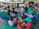 Ein Gruppe Kinder sitzt in Sitzsäcken vor einer digitalen Tafel
