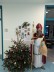 Mann in Nikolauskostüm neben Tannenbaum