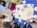 Schülergruppe rund um einen Tisch mit Mosaiksteinen