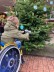Junge im Rollstuhl hängt Sterne aus Wäscheklammern an den Tannenbaum