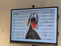 Dackel-Handpuppe vor Notenblatt