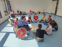 Eine Gruppe Schülerinnen sitzen während des Selbstbehauptungskurs in einem Kreis in der Turnhalle