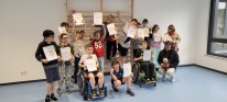 Kinder in einer Sporthalle mit Urkunden
