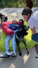 Junge im Sitzsack mit daneben liegendem Schulhund Mace